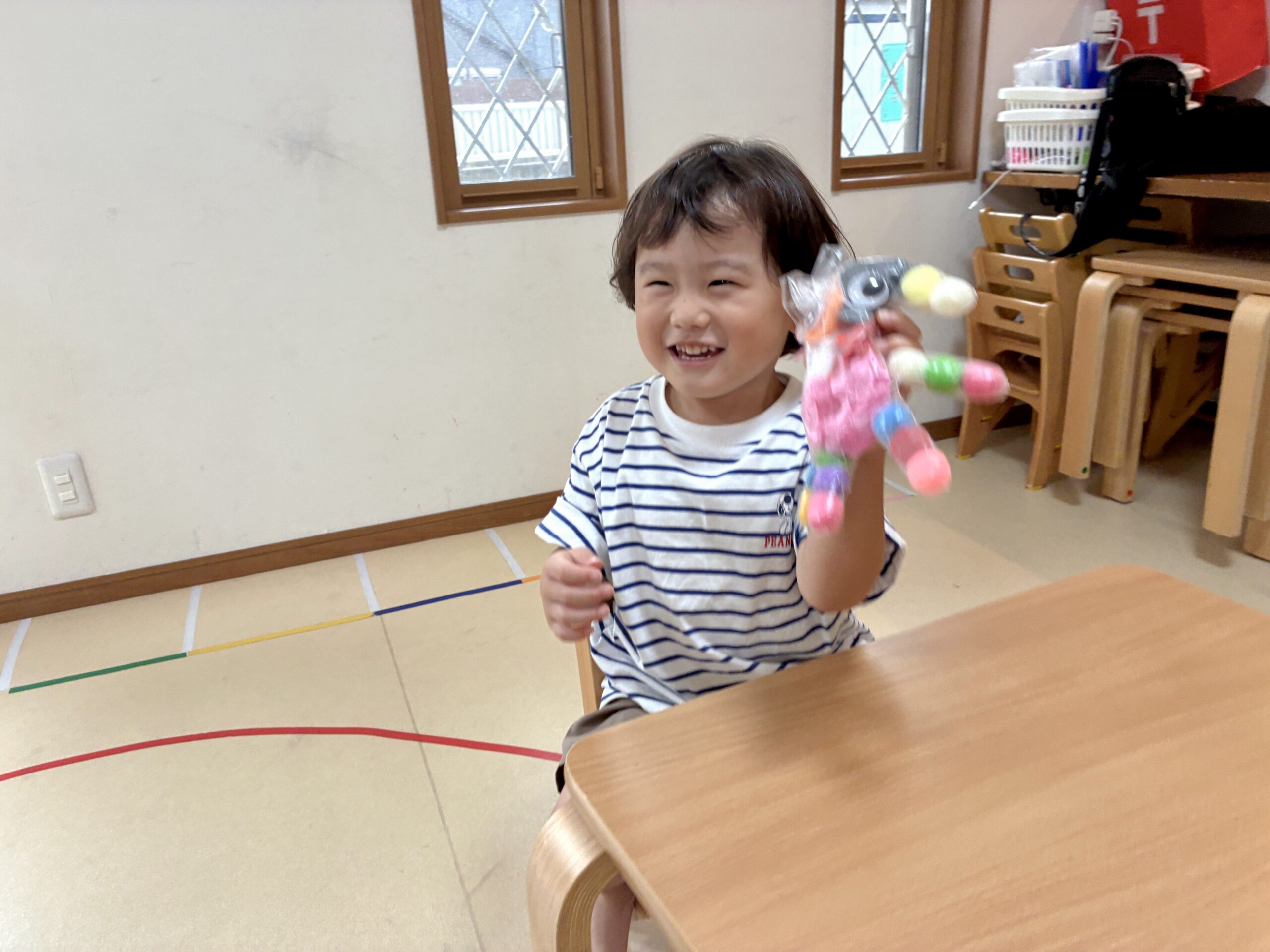 手袋で作ったおばけを持ち上げて笑う子ども