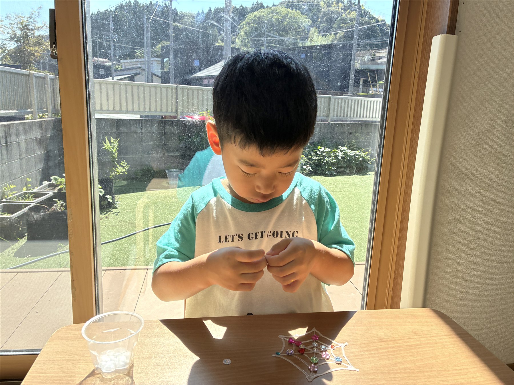 蜘蛛の巣の形のシールを剥がすこども
