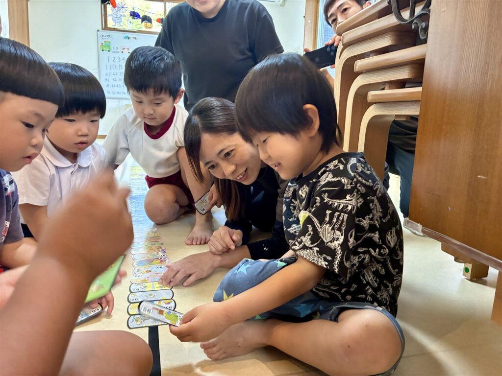 並んだ数字のカードを囲むこどもたちとスタッフ