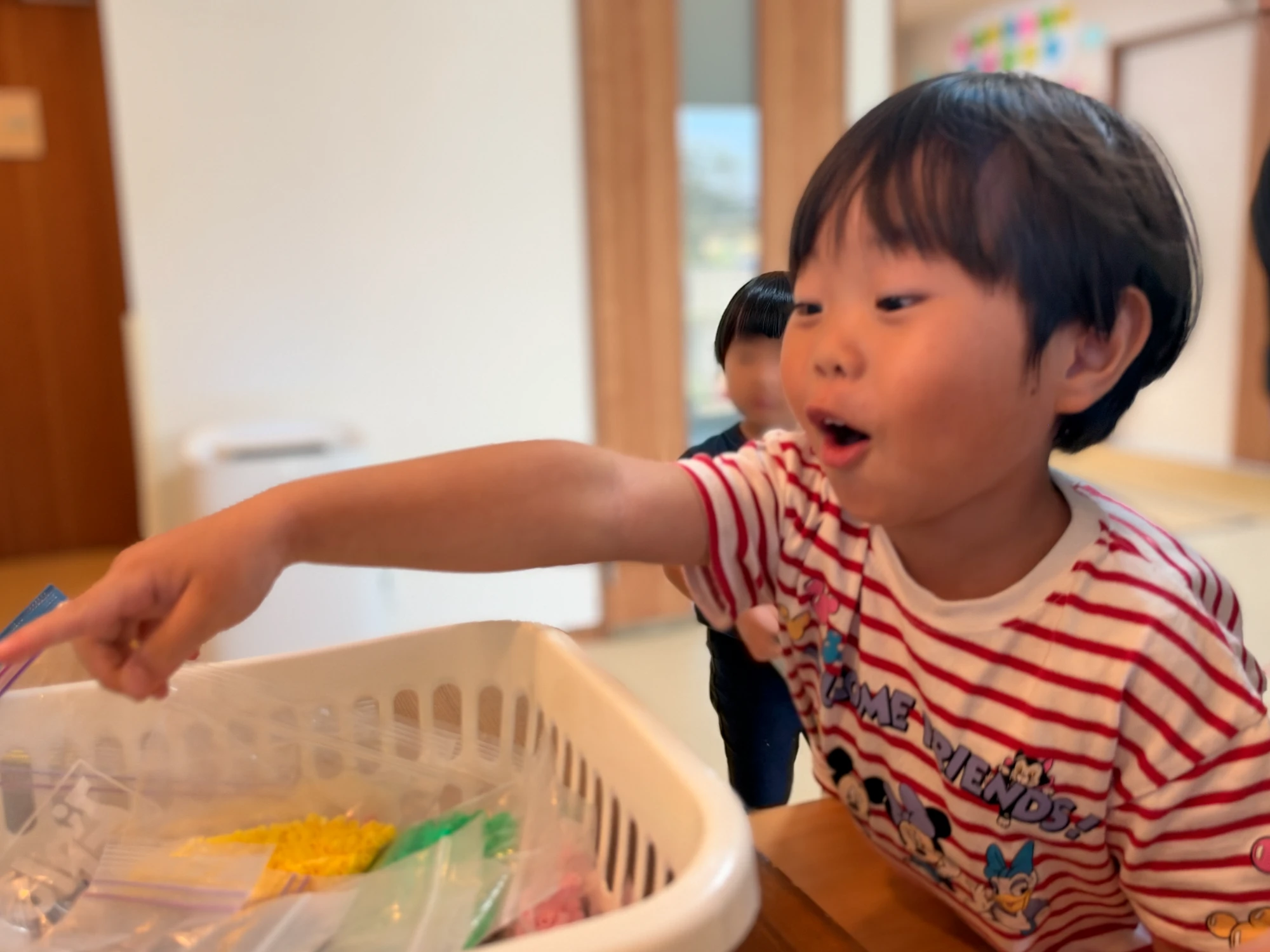 室内で虫探し遊びをしながら指さす子ども