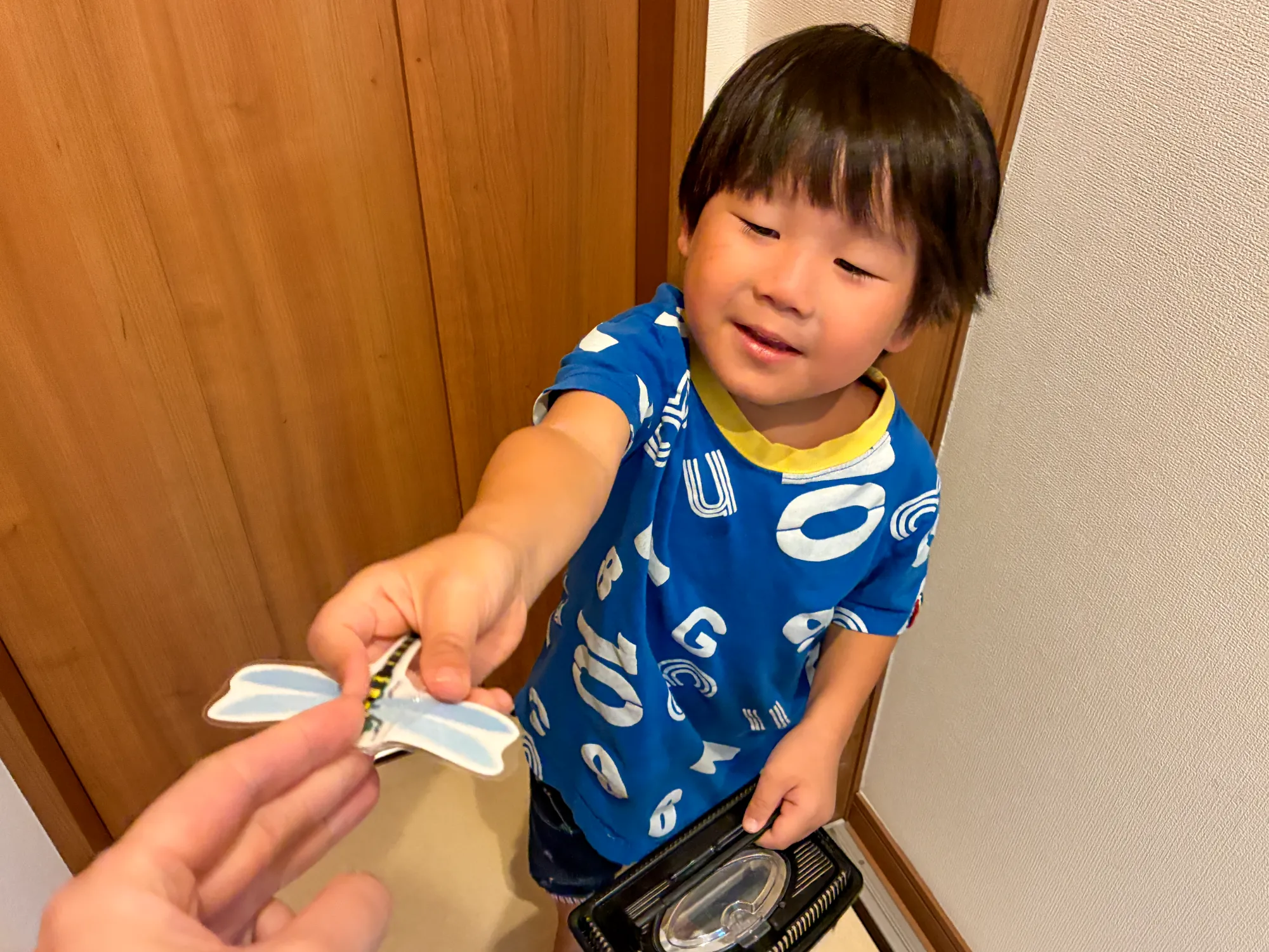 見つけた虫のカードを職員に手渡す子ども