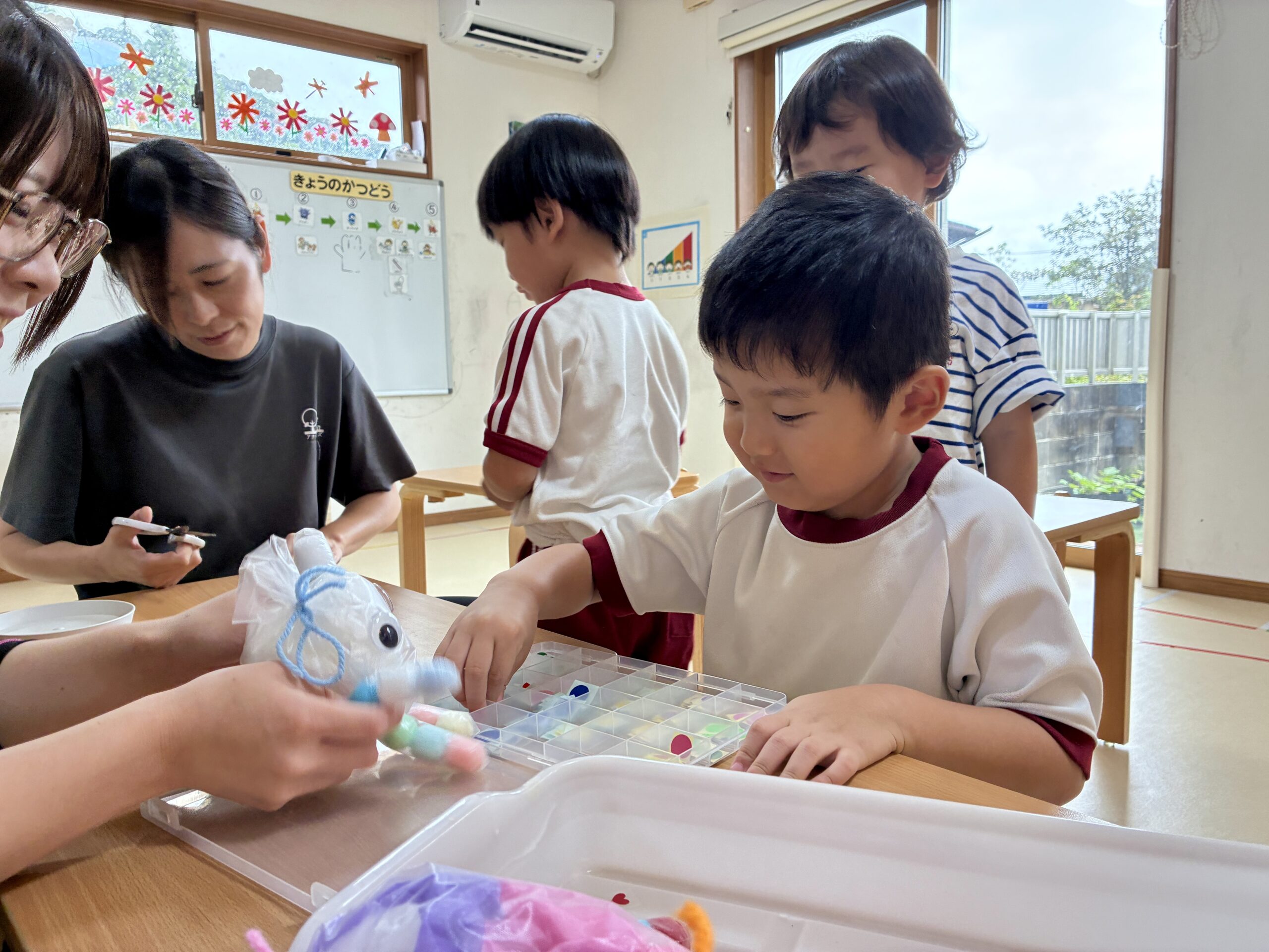 職員が手にしたおばけを見つめる子どもたちと職員